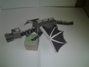 Side view of Enderdragon papercraft on a grass block cutout