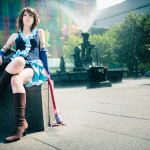Songstress Yuna Cosplay sitting by water fountain