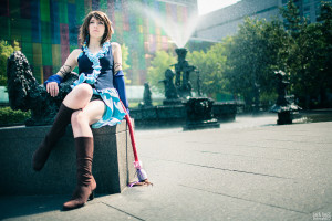 Songstress Yuna Cosplay sitting by water fountain