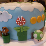 side view of mario cake showing goomba, 1-up, coins