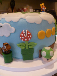 side view of mario cake showing goomba, 1-up, coins